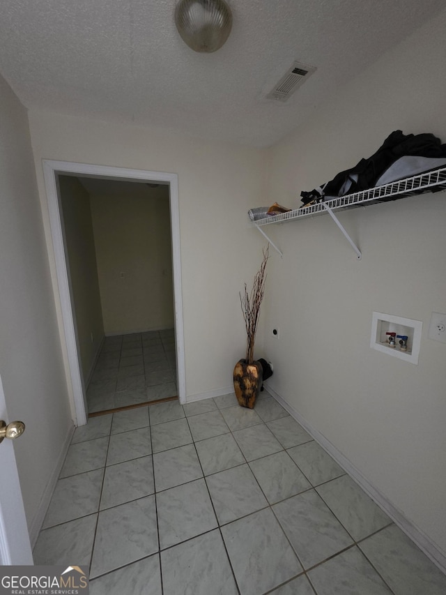 clothes washing area featuring washer hookup, laundry area, a textured ceiling, visible vents, and light tile patterned floors