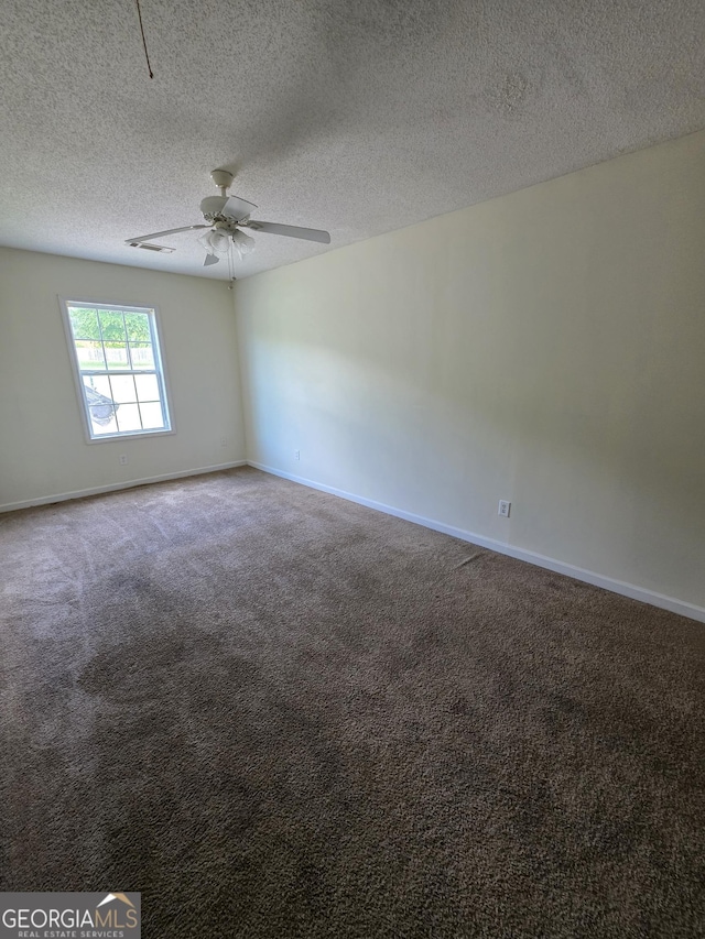 carpeted spare room with a textured ceiling, baseboards, and ceiling fan