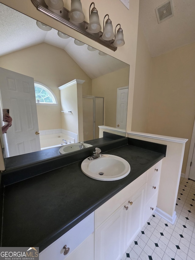 bathroom with a bath, visible vents, a shower stall, vanity, and lofted ceiling
