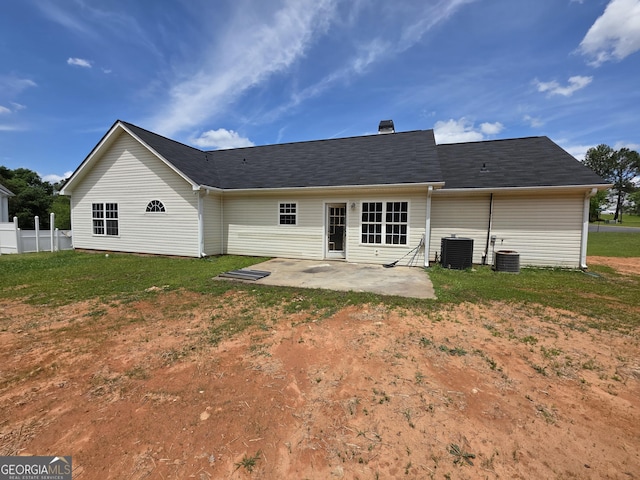 rear view of property featuring a patio, a yard, and central AC
