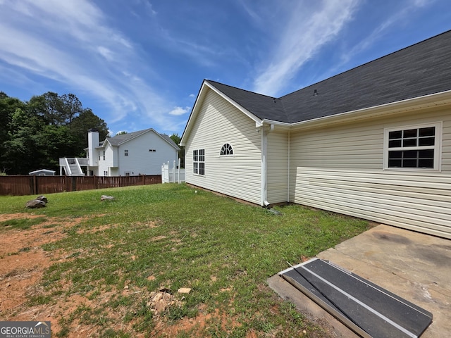 exterior space featuring a lawn and fence