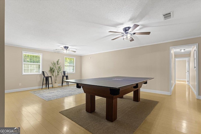 playroom with crown molding, baseboards, a ceiling fan, and visible vents