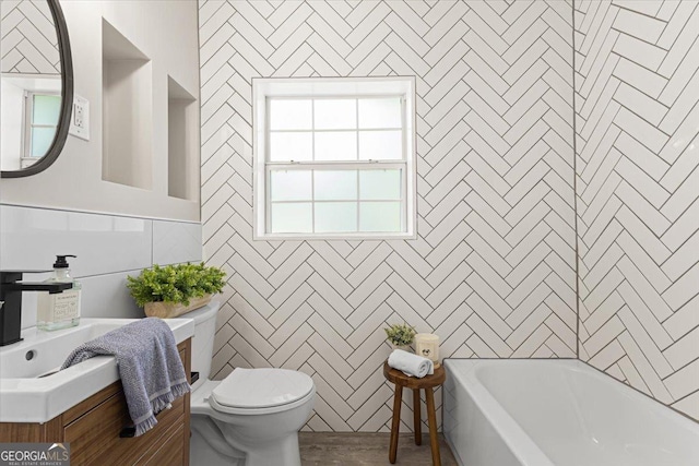 bathroom with toilet, tile walls, and vanity