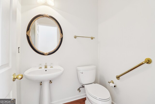 half bathroom featuring toilet and baseboards