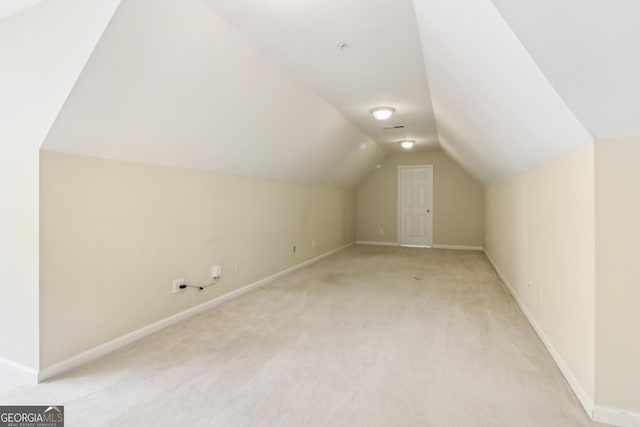 bonus room with light colored carpet, baseboards, and lofted ceiling