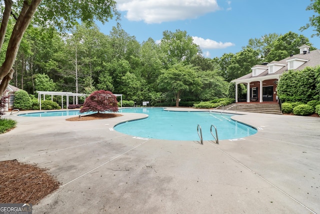pool with a patio and a pergola