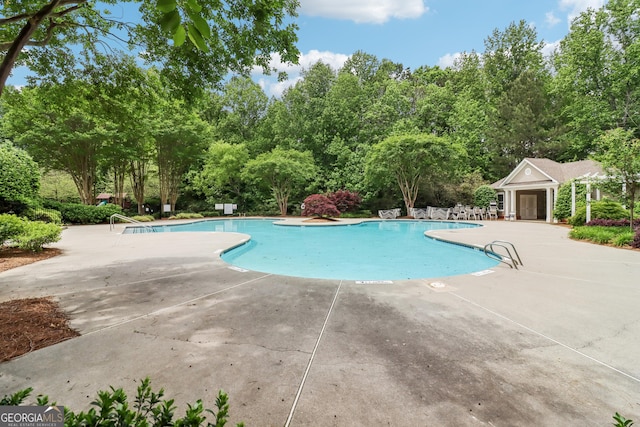 community pool featuring fence and a patio area