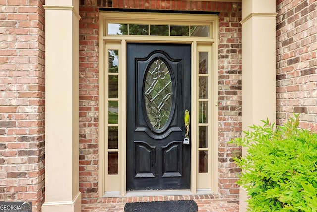 entrance to property featuring brick siding