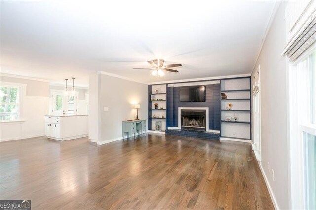 5873 Trellis Ct, Powder Springs, GA 30127 - unfurnished living room with ceiling fan, a brick fireplace, baseboards, ornamental molding, and dark wood-type flooring