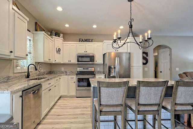 346 Woodland Ln, Hayesville, NC 28904 - kitchen with a breakfast bar area, arched walkways, a sink, a notable chandelier, and stainless steel appliances