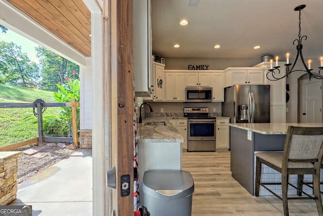 346 Woodland Ln, Hayesville, NC 28904 - kitchen with appliances with stainless steel finishes, light stone counters, white cabinets, a chandelier, and recessed lighting