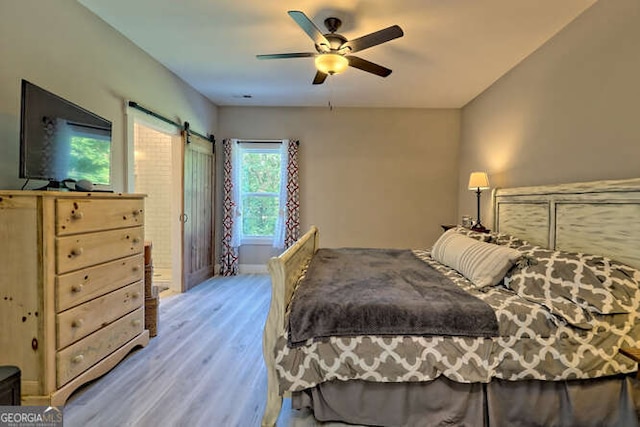 346 Woodland Ln, Hayesville, NC 28904 - bedroom featuring a ceiling fan, a barn door, and wood finished floors