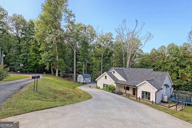 346 Woodland Ln, Hayesville, NC 28904 - view of front of property featuring an outdoor structure, a front lawn, a storage unit, board and batten siding, and a trampoline