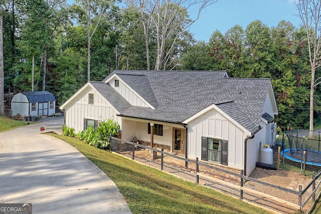 346 Woodland Ln, Hayesville, NC 28904 - modern farmhouse style home with a trampoline, board and batten siding, roof with shingles, and fence