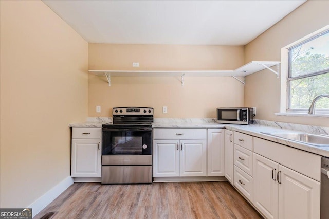 613 Bradley Ave, Lafayette, GA 30728 - kitchen featuring appliances with stainless steel finishes, a sink, light wood finished floors, white cabinetry, and baseboards