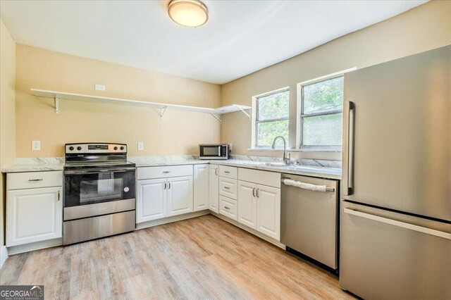 613 Bradley Ave, Lafayette, GA 30728 - kitchen featuring a sink, white cabinets, stainless steel appliances, and light wood-style flooring