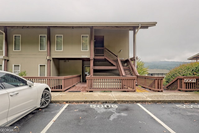 multi unit property featuring stairs and uncovered parking