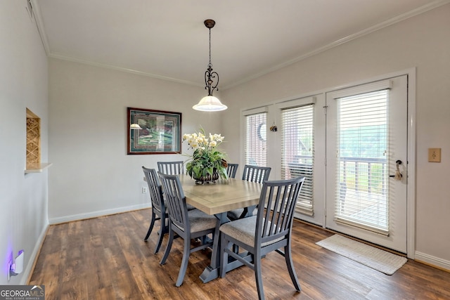 dining space featuring baseboards, ornamental molding, and wood finished floors