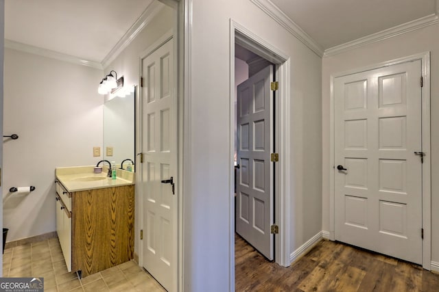 bathroom featuring vanity, ornamental molding, and baseboards