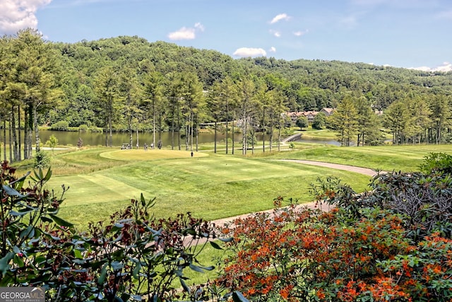 view of home's community featuring a yard, a water view, and golf course view