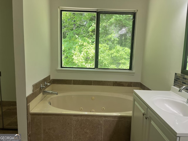 full bath featuring a jetted tub and vanity