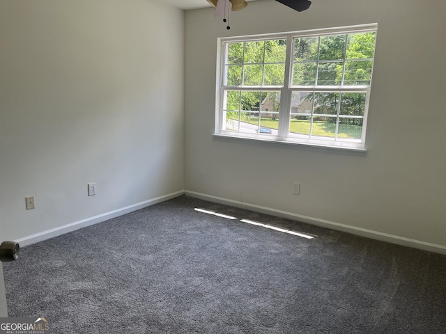 carpeted spare room featuring baseboards and ceiling fan