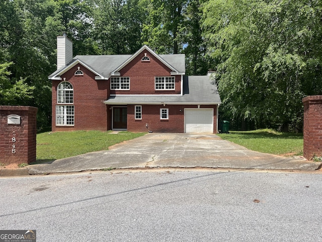 traditional-style home featuring an attached garage, driveway, a front yard, and a chimney