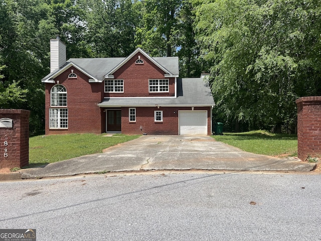 traditional-style house with an attached garage, a front lawn, brick siding, and concrete driveway