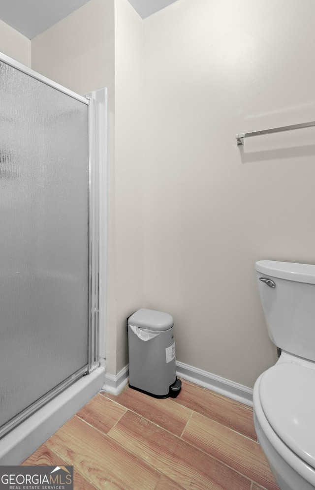 142 Old Hampton Way, Hampton, GA 30228 - full bathroom featuring baseboards, a stall shower, toilet, and wood finished floors