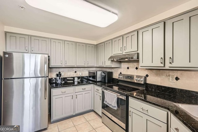 199 14th St Unit 2502, Atlanta, GA 30309 - kitchen with light tile patterned flooring, under cabinet range hood, dark stone countertops, backsplash, and stainless steel appliances