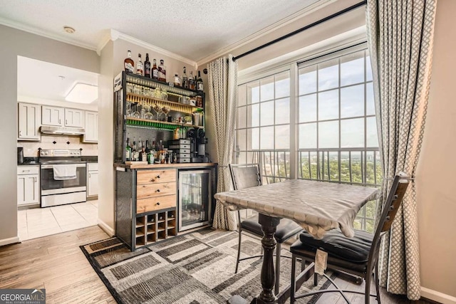 199 14th St Unit 2502, Atlanta, GA 30309 - bar with stainless steel electric range oven, a dry bar, light wood finished floors, beverage cooler, and under cabinet range hood
