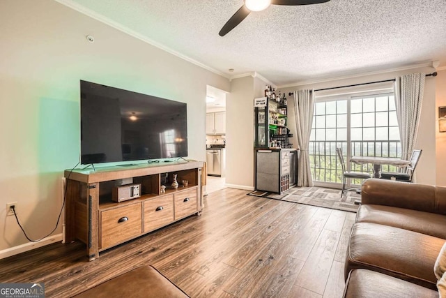 199 14th St Unit 2502, Atlanta, GA 30309 - living room featuring a textured ceiling, a ceiling fan, baseboards, ornamental molding, and hardwood / wood-style flooring