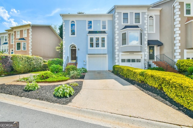 view of front facade with an attached garage, stucco siding, and driveway
