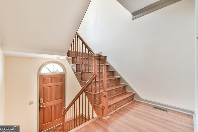 staircase with wood finished floors and visible vents