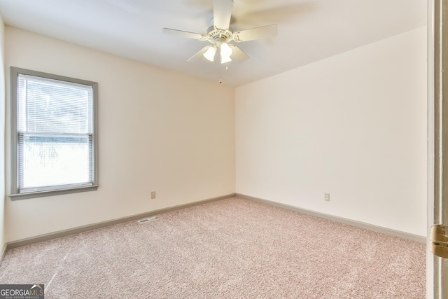 empty room featuring visible vents, carpet, ceiling fan, and baseboards