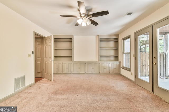 interior space featuring light colored carpet, ceiling fan, and visible vents