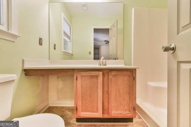 half bathroom with vanity, tile patterned floors, baseboards, and toilet