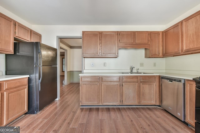 kitchen featuring light wood-style floors, freestanding refrigerator, dishwasher, and light countertops