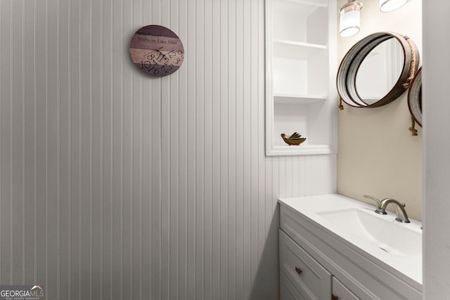 bathroom featuring vanity and wooden walls