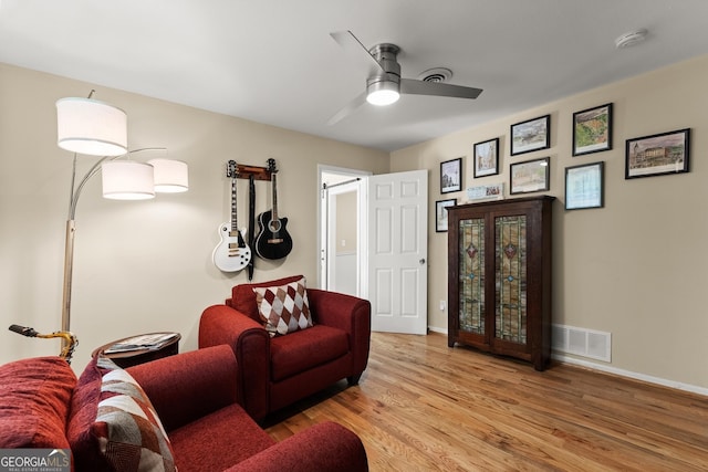 living room with a ceiling fan, baseboards, visible vents, and light wood-type flooring