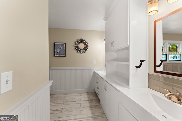 bathroom featuring vanity, tasteful backsplash, and wainscoting