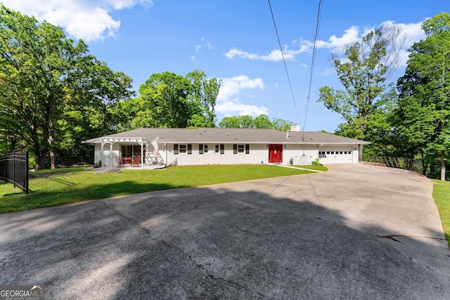 ranch-style home with fence, an attached garage, concrete driveway, and a front lawn