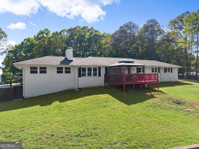 back of property featuring a lawn, a wooden deck, a gazebo, and a chimney