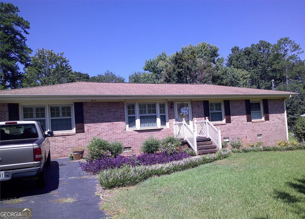 single story home with brick siding, a shingled roof, crawl space, and a front yard