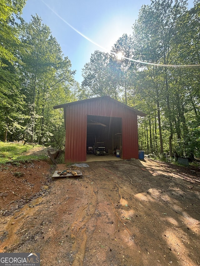 view of outdoor structure featuring an outbuilding and a forest view