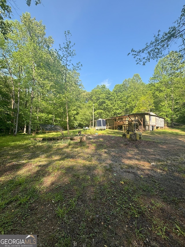 view of yard featuring an outdoor structure and a view of trees