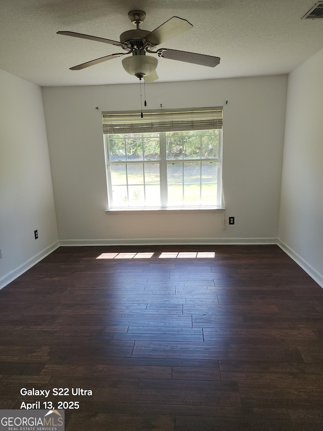 empty room featuring baseboards, a ceiling fan, wood finished floors, and visible vents