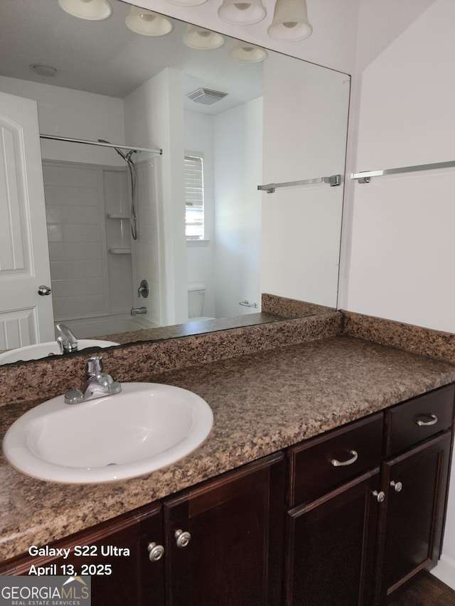 full bathroom with toilet, visible vents, and vanity
