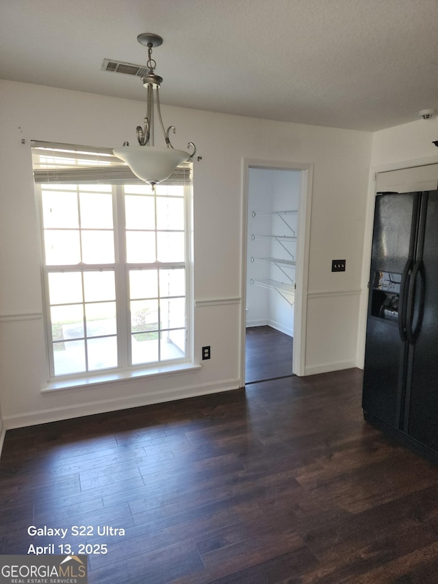 unfurnished dining area with baseboards, dark wood finished floors, and visible vents