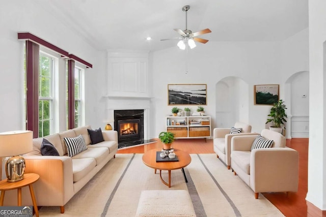 1544 Overview Cir, Lawrenceville, GA 30044 - living room with arched walkways, light wood-type flooring, a high end fireplace, and a ceiling fan
